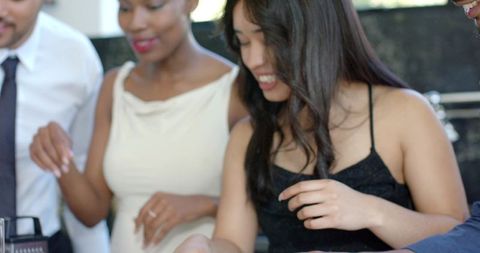 African american friends socializing in modern kitchen smiling woman reaching for speaker