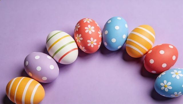 Hand-painted pastel Easter eggs forming curved arc on purple surface for spring celebration