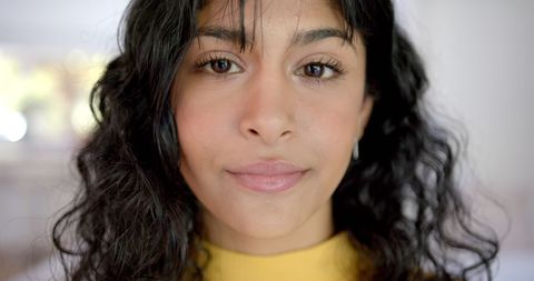 Confident Biracial Teenager with Curly Hair Smiling Indoors