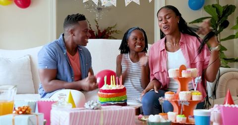 Family Celebrating Daughter's Birthday with Cake and Smiles