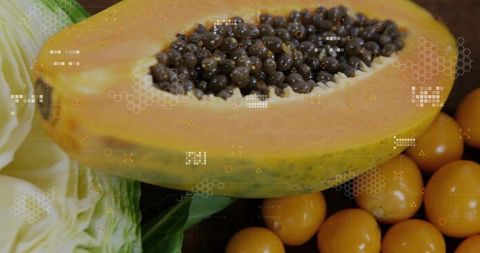 Papaya and golden berries on wooden surface with fresh leaves