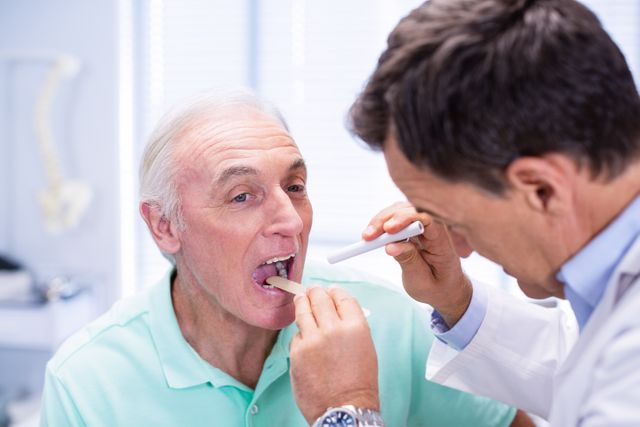 Doctor examining senior patients mouth in clinic