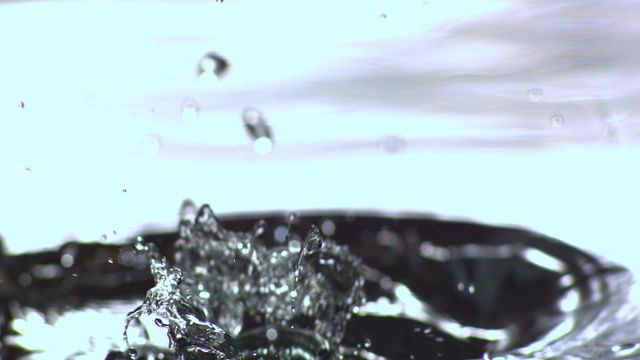 This captivating scene captures the moment a glass bottle plunges into water, creating a dynamic splash with droplets suspended in mid-air. Ideal for use in advertisements for water conservation, hydration campaigns, or environmental initiatives. The intricate details can also serve educational purposes about fluid dynamics or promotional materials related to sustainable practices involving glass recycling.