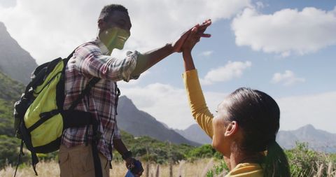 Couple high-fiving while begging in scenic mountain view