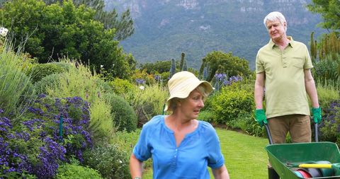 Senior Couple Gardening Together in Lush Backyard