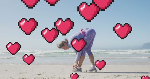 Woman Tying Shoe on Beach with Pixel Hearts Overlay