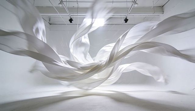 Billowing white fabric sculpture conveying motion, minimalist high-key studio installation