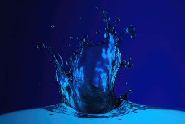 Close up of blue liquid splashing on blue background created using generative ai technology. Liquid and colour concept digitally generated image.