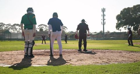 Community park baseball game with umpire overseeing play