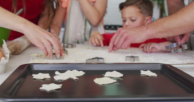 Family engaged in baking Christmas cookies together, highlighting the joy and bonding during the holidays. Perfect for holiday advertisements, family-themed products, baking blogs, and festive greeting cards.