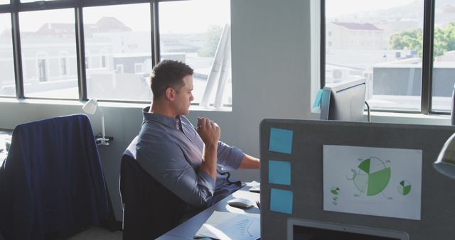 Thoughtful caucasian casual businessman sitting at desk using computer in office - Download Free Stock Photos Pikwizard.com