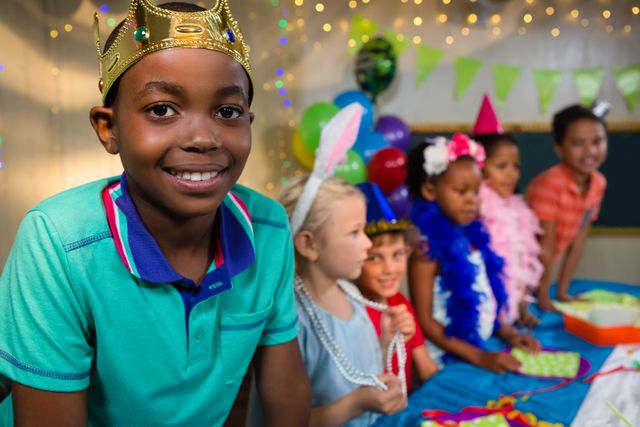 Portrait of boy wearing crown with friends in background during party