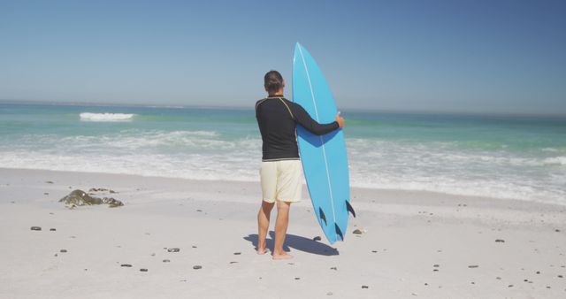 Senior caucasian man holding surfboard on beach. Senior lifestyle, realxation, nature, free time and vacation.