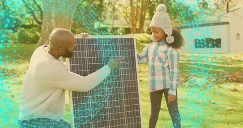 Father teaching daughter solar panel basics in backyard demonstrating renewable energy for kids