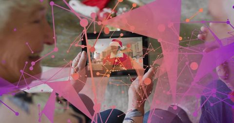 Seniors holding tablet watching virtual santa on video call with festive holiday overlay
