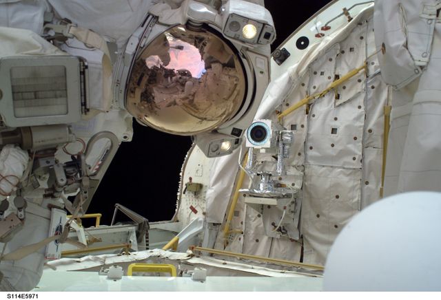 S114-E-5971 (1 August 2005) --- Astronaut Stephen K. Robinson, mission specialist, floats in the cargo bay on  Discovery's aft end during the second scheduled spacewalk for STS-114.