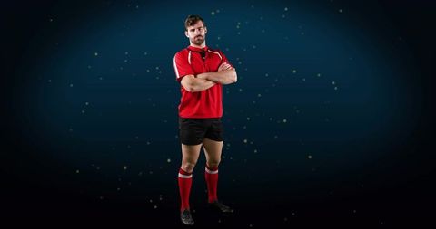Standing rugby athlete crossing arms in red jersey with whistle and confident stance