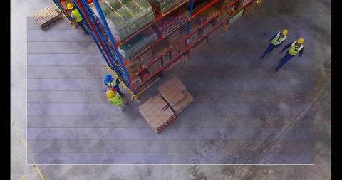 Warehouse workers inspecting inventory with safety gear and headsets
