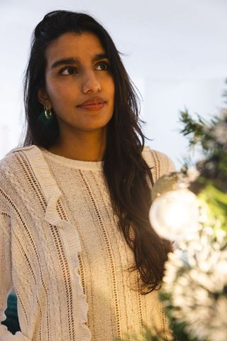 Thoughtful Asian Woman with Festive Decor in Minimalist Setting