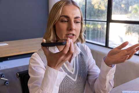 Business Professional Using Smartphone for Communication in Modern Office