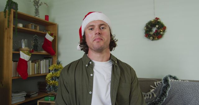 Man Celebrating Christmas at Home Wearing Santa Hat - Download Free Stock Images Pikwizard.com