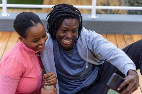 African american couple taking selfie on deck after outdoor workout