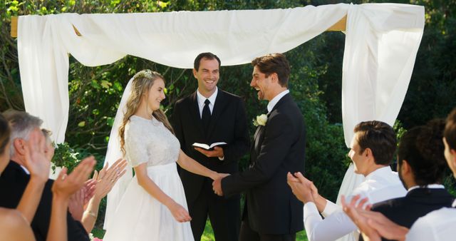 Joyful outdoor wedding ceremony with happy couple and guests clapping - Download Free Stock Images Pikwizard.com