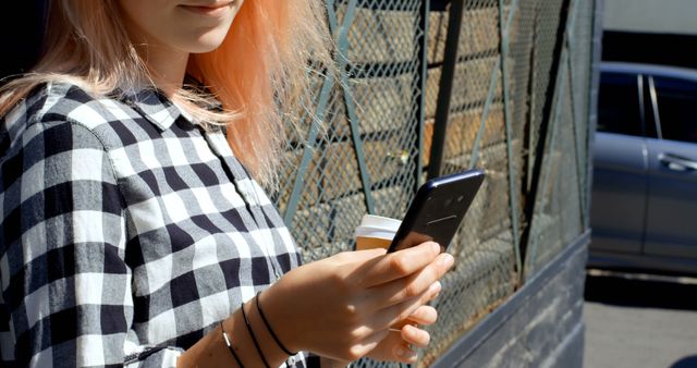 Young Woman Texting on Smartphone While Holding Coffee Cup Outdoors - Download Free Stock Images Pikwizard.com