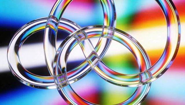Interlocking glass rings refracting rainbow light abstract geometry prism background