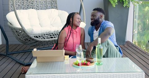 Romantic Couple In Relaxed Patio Setting With Wine