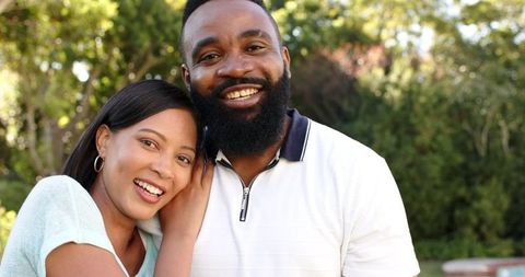 Happy Diverse Couple Embracing in Sunlit Garden