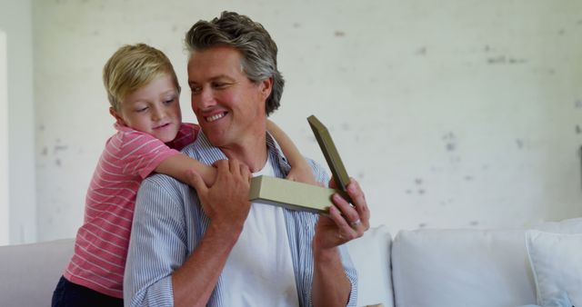 Father Receiving Gift from Son in Living Room - Download Free Stock Images Pikwizard.com