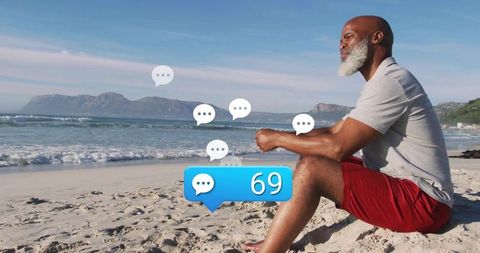 Man relaxing at beach with digital chat icon overlays