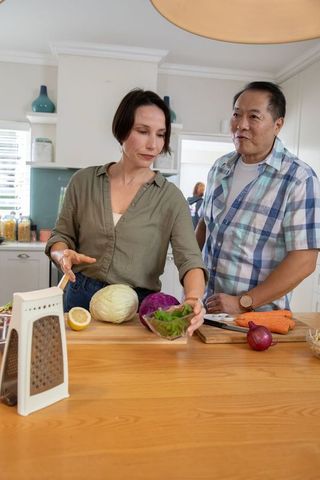 Diverse Couple Prepares Vegetables in Contemporary Home Kitchen