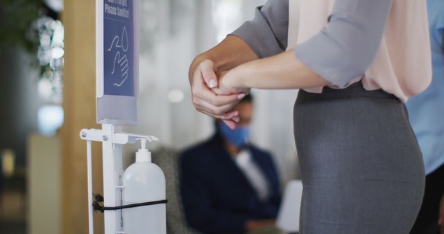 Close-Up of Woman Using Hand Sanitizer Dispenser in Modern Office - Download Free Stock Images Pikwizard.com