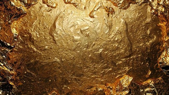 Luxurious Gold Metal Swirl with Textured Surface and Fiery Highlights