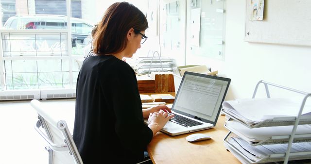 Female Professional Working on Laptop in Modern Office - Download Free Stock Images Pikwizard.com