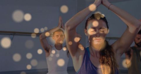 Group practicing yoga and meditation at ballet barre with bokeh for mindfulness