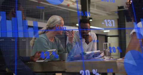 Business team analyzing data overlays and reviewing reports in modern open-plan office