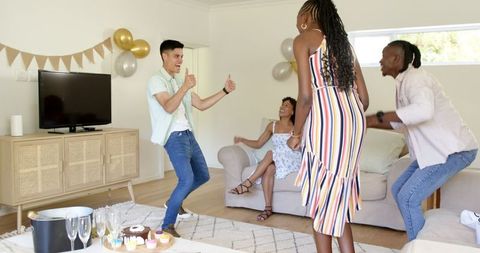 Joyful Friends Dancing and Celebrating at Home Gathering