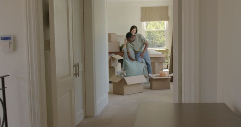 Couple Unpacking Boxes in New Home with Joyful Anticipation
