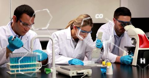 Multidisciplinary research team pipetting and analyzing samples in modern lab with microscope