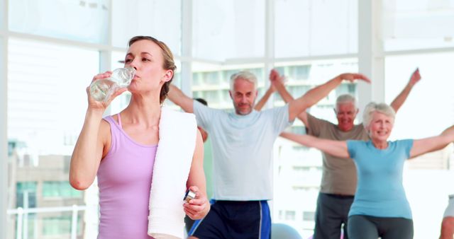 Group of seniors exercising and staying hydrated in modern fitness studio - Download Free Stock Images Pikwizard.com