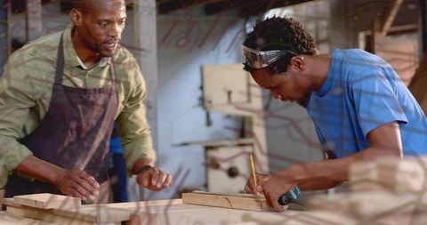 Carpentry Apprentice Marking Plank While Instructor Guides Hands-On Workshop Training