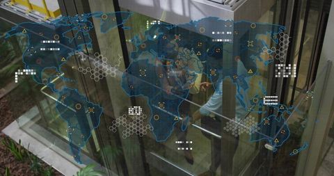 Corporate team pressing elevator buttons in glass atrium with digital world map overlay