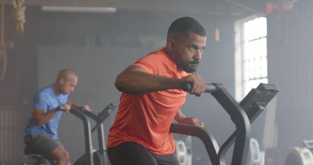 Focused Men Exercising on Rowing Machines in Gym - Download Free Stock Images Pikwizard.com