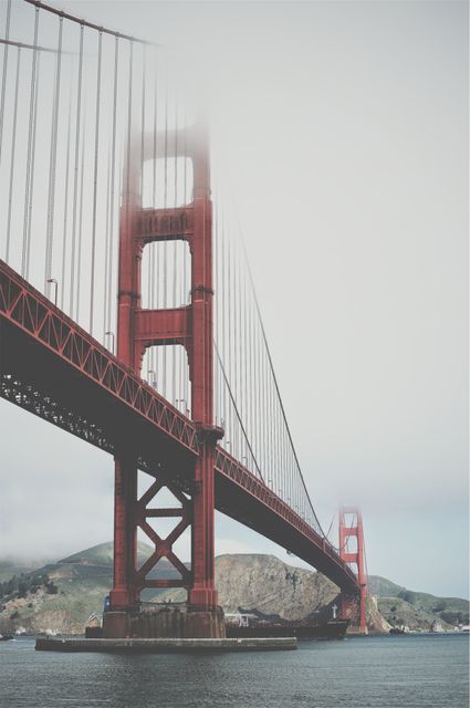 This striking view of the Golden Gate Bridge enveloped in fog is perfect for promoting travel to San Francisco and highlighting iconic American landmarks. Suitable for use in articles about engineering marvels, city guides, and tourism ads.