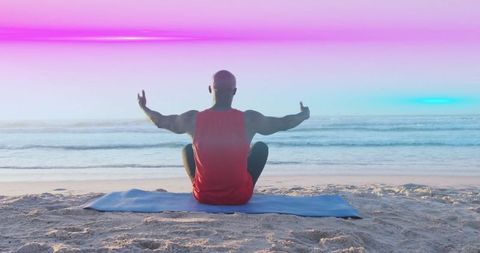 Man Meditating on Vibrant Beach at Sunrise