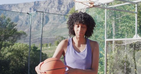 Focused Female Basketball Player Holding Ball Outdoors - Download Free Stock Images Pikwizard.com