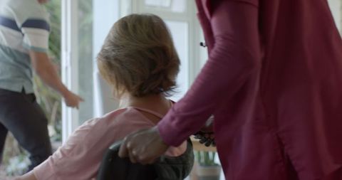 Caregiver assisting senior man in wheelchair indoors